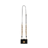 Alessa Black Card Holder with gold details and a sculptural detachable strap, showcasing artistry and sophistication.