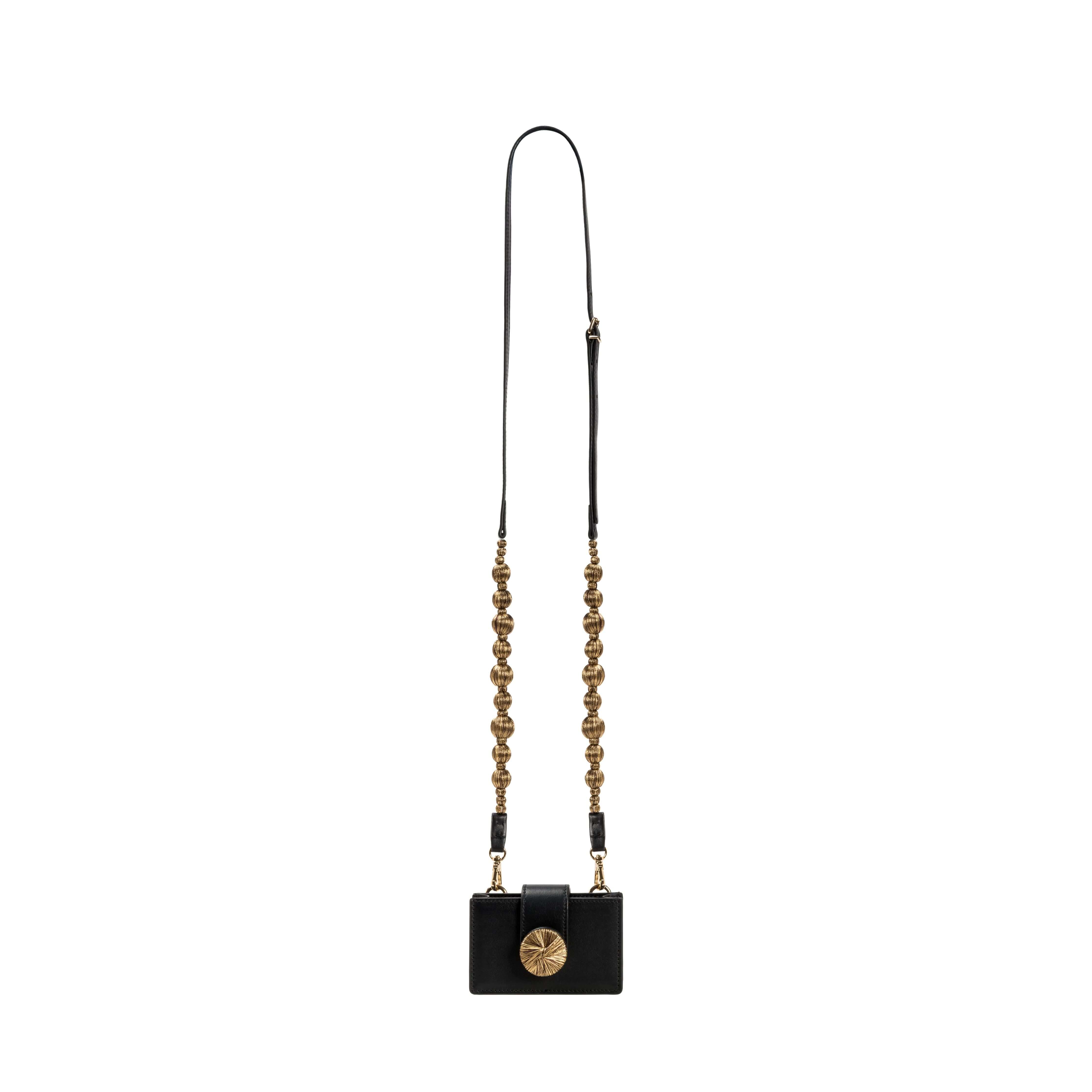 Alessa Black Card Holder with gold details and a sculptural detachable strap, showcasing artistry and sophistication.