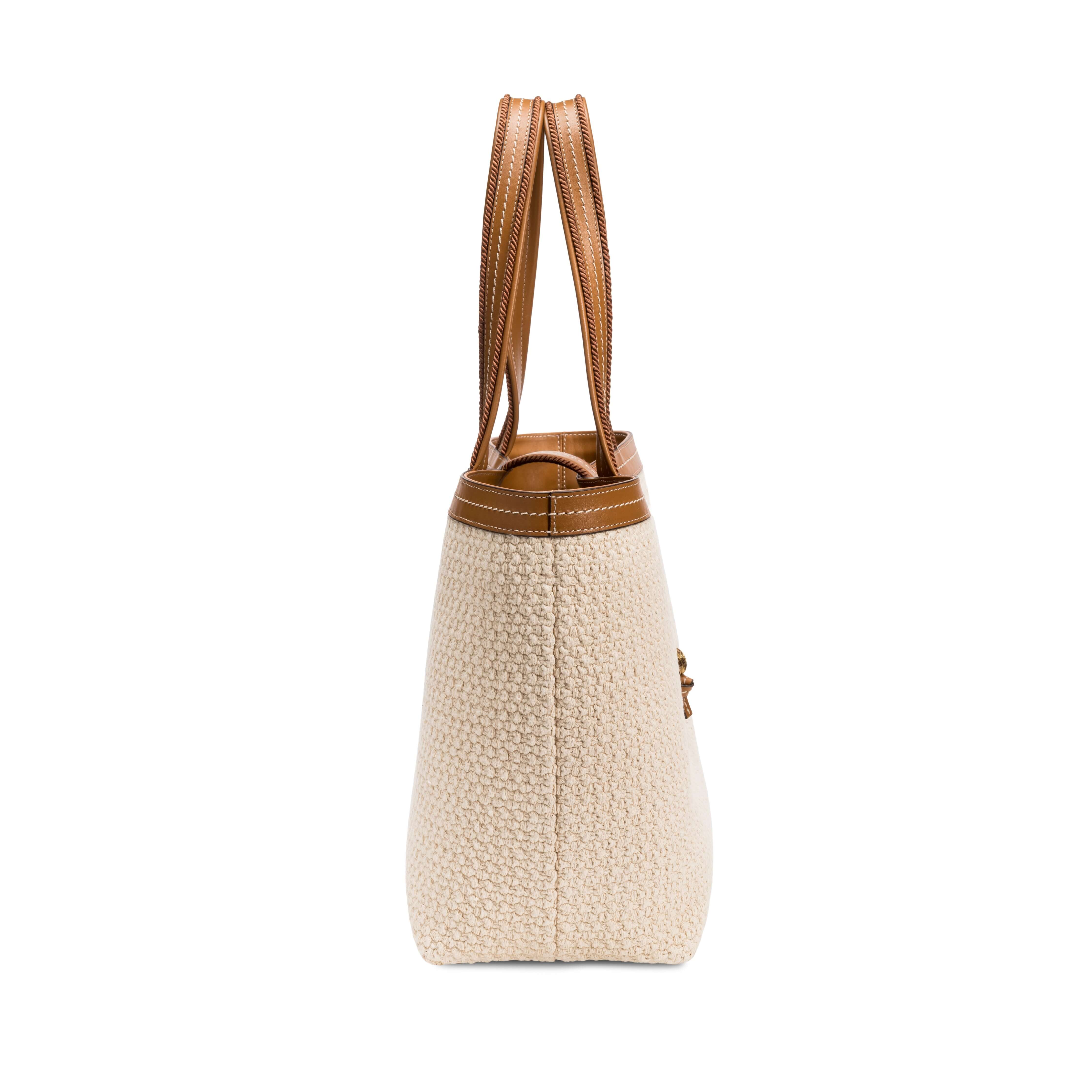 Side view of a Boho Chic medium off-white tote bag featuring textured fabric and brown leather accents.