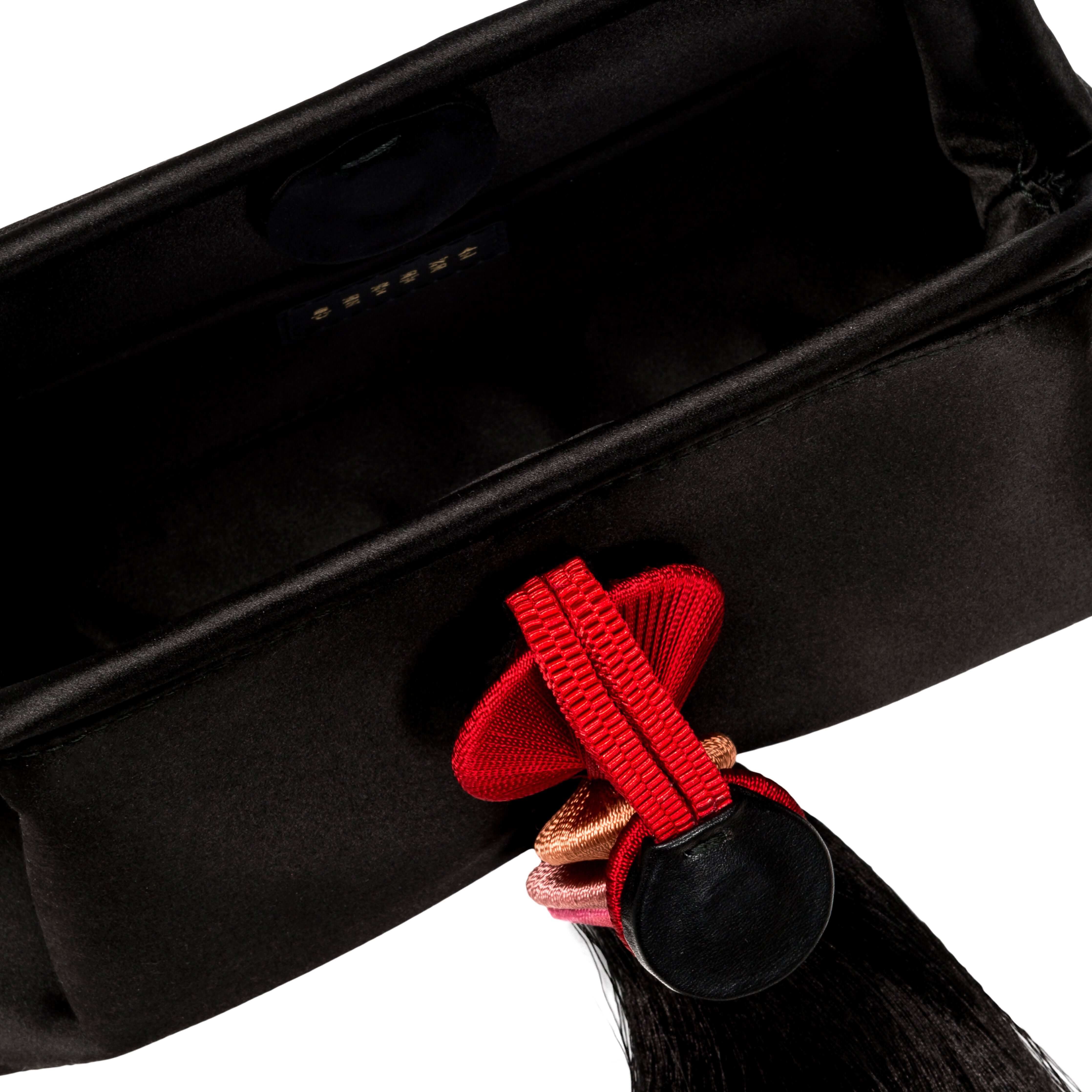 Inside view of the Alessa Black Pouch Bag featuring a magnetic closure and decorative tassel.