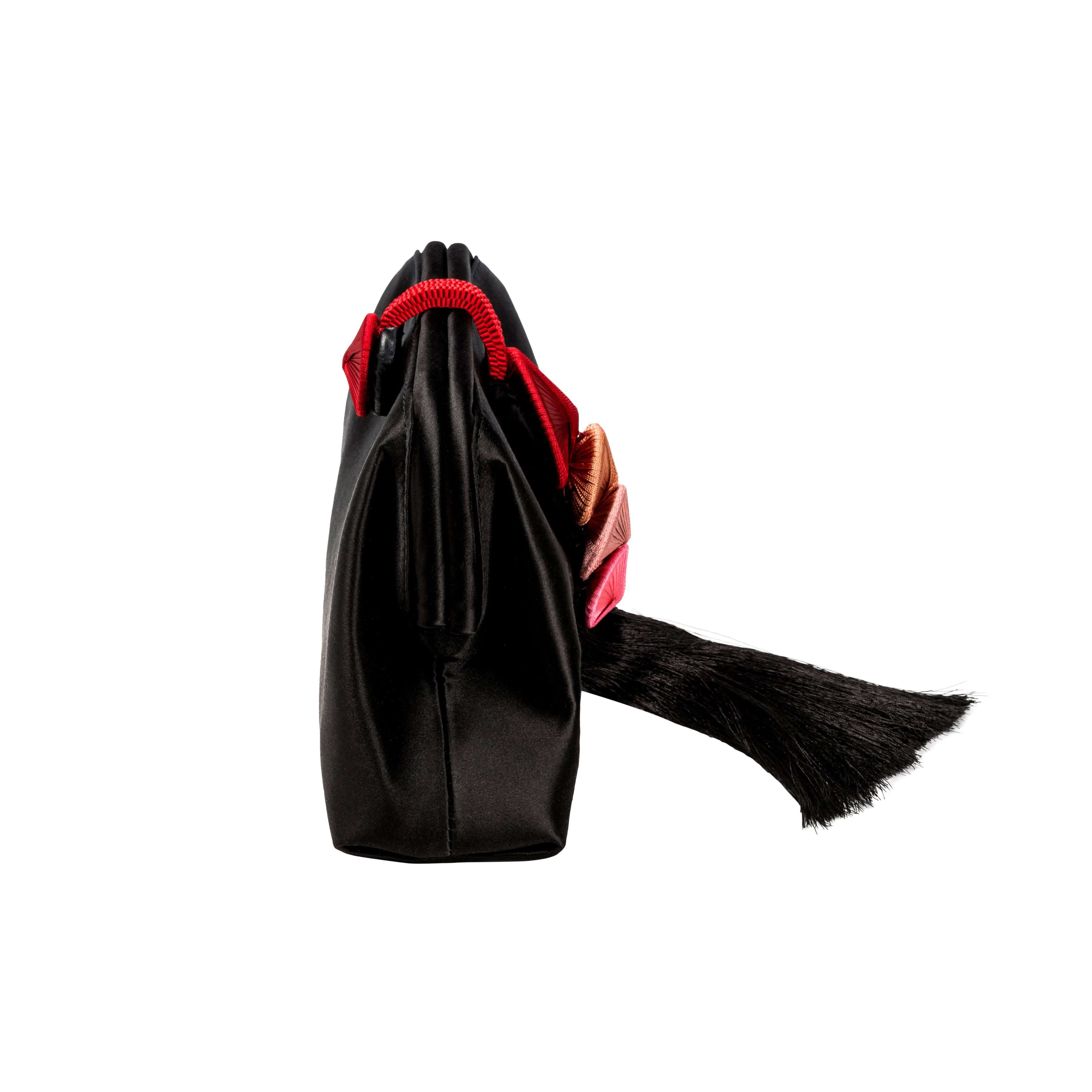 Alessa Black Pouch Bag showcasing its elegant side view with intricate thread-wrapped design and stylish tassel.