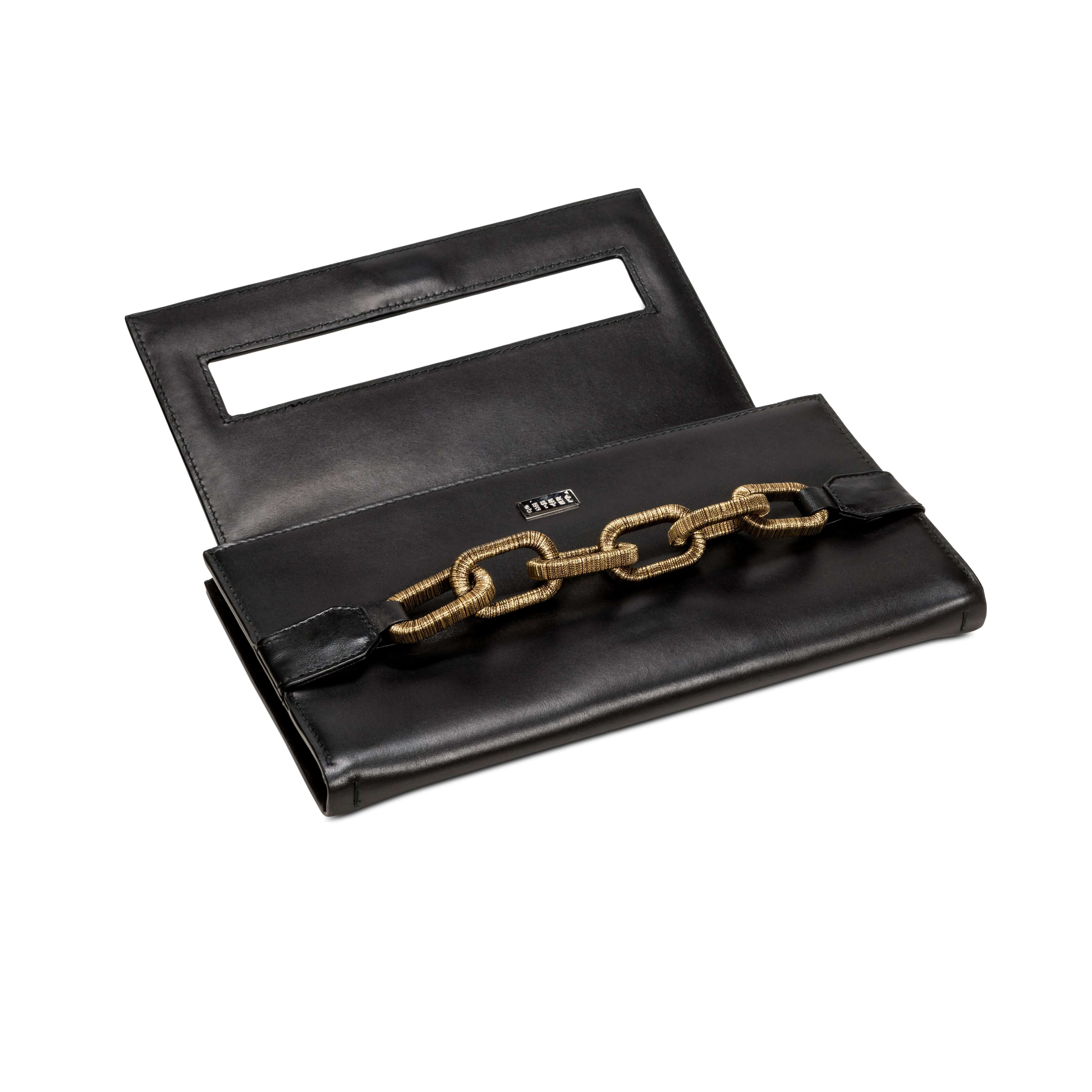 Elegant black clutch with antique gold chain detail, featuring a sleek design and modern aesthetic.