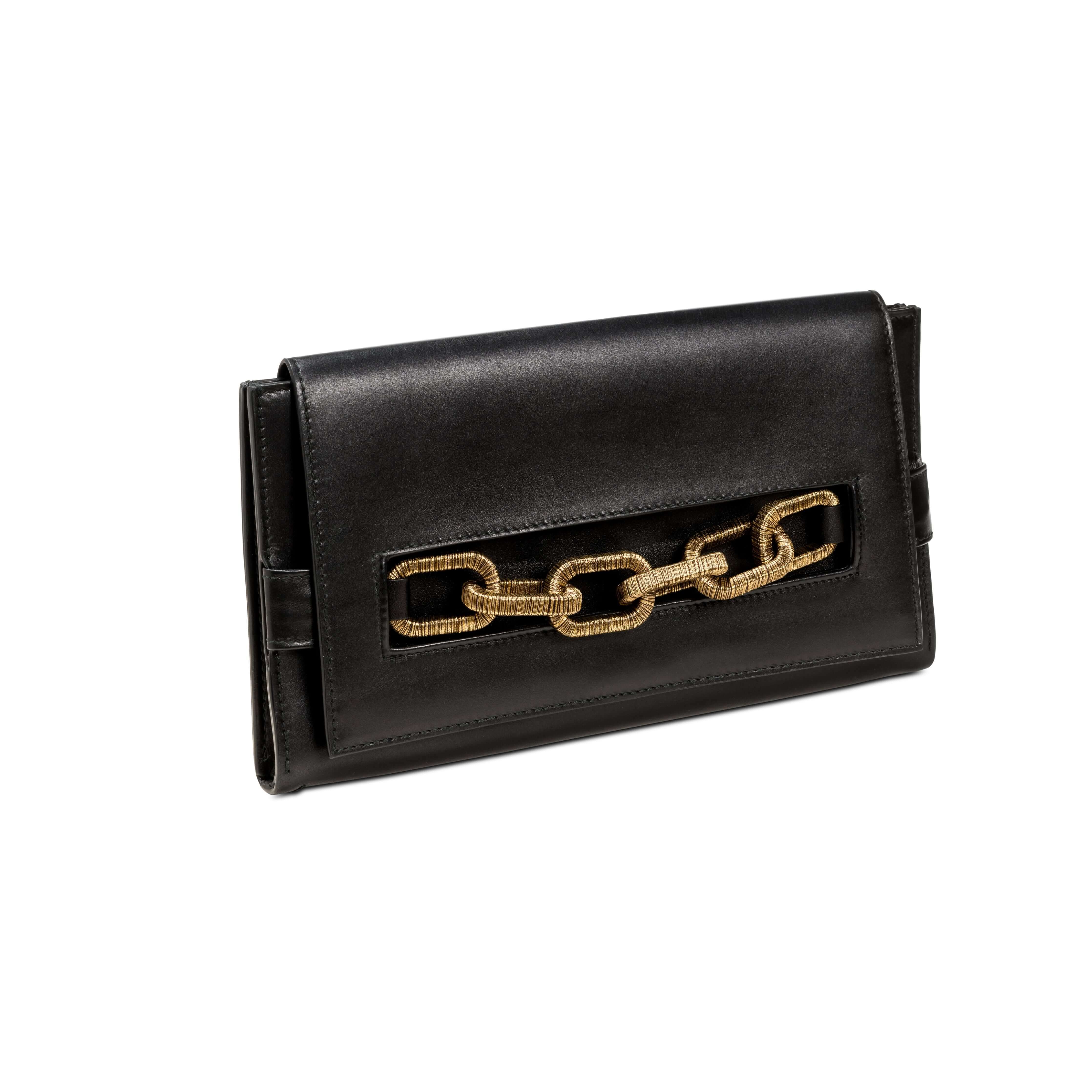 Elegant black clutch purse featuring a distinctive antique gold chain accent, stylish and versatile for any occasion.