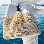 Melita Off-White Large Tote Bag with tassel, showcasing intricate crochet and bohemian design by the water.
