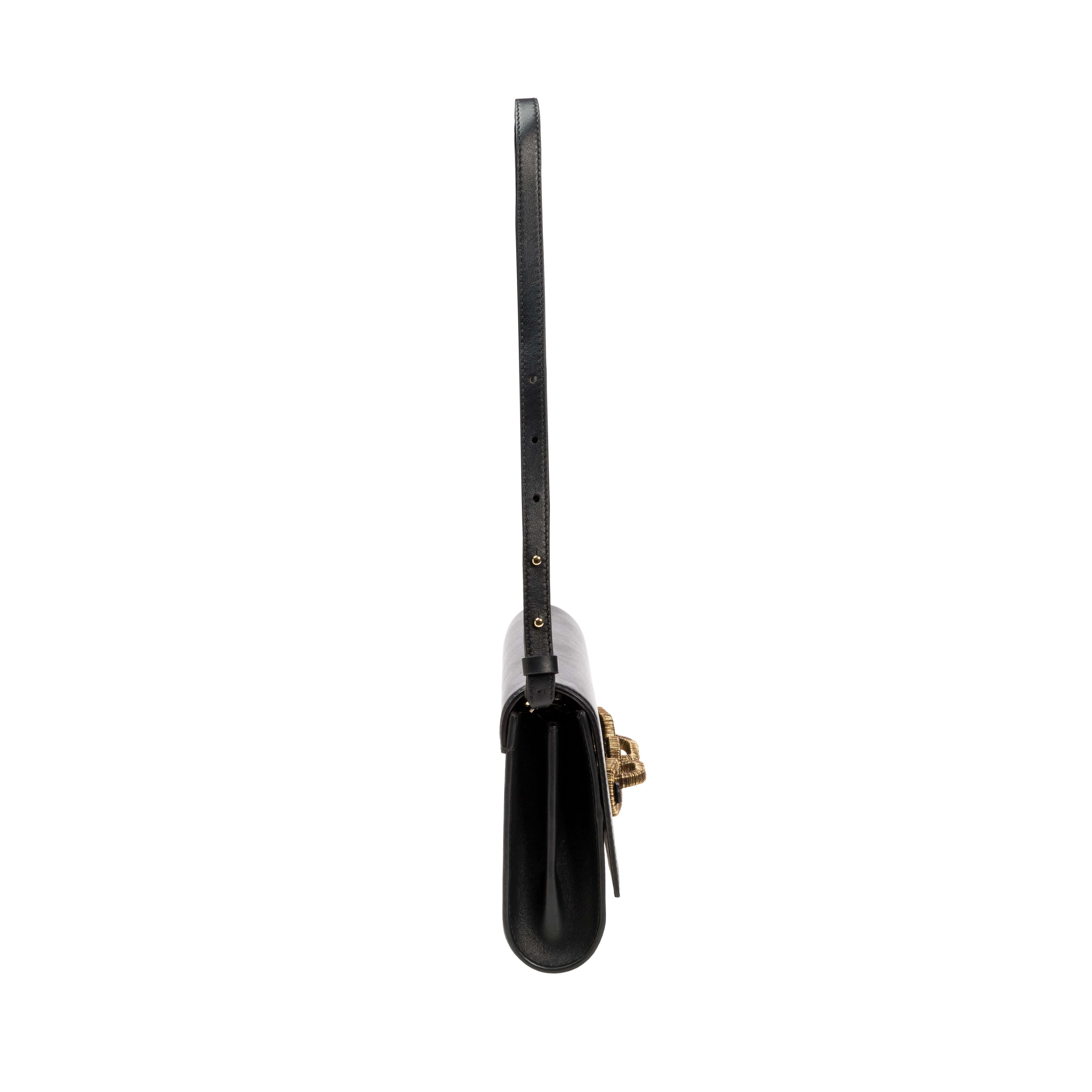 Catena Day to Night Black Bag showcasing a sleek, minimalist design with a long leather strap and elegant closure.