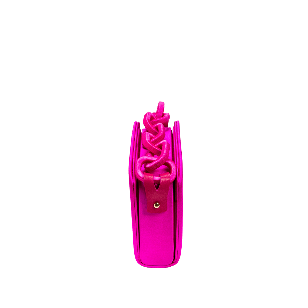 Front view of the Catena Fuchsia Two-Sided Bag showcasing its braided chain-link handle and vibrant fuchsia silk satin finish.