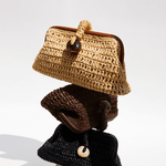 Stack of three stylish pouch bags in natural raffia, showcasing a rustic charm and elegant design.