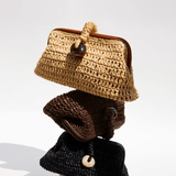 Stack of three artisan-crafted pouch bags made from natural raffia in umber tones.