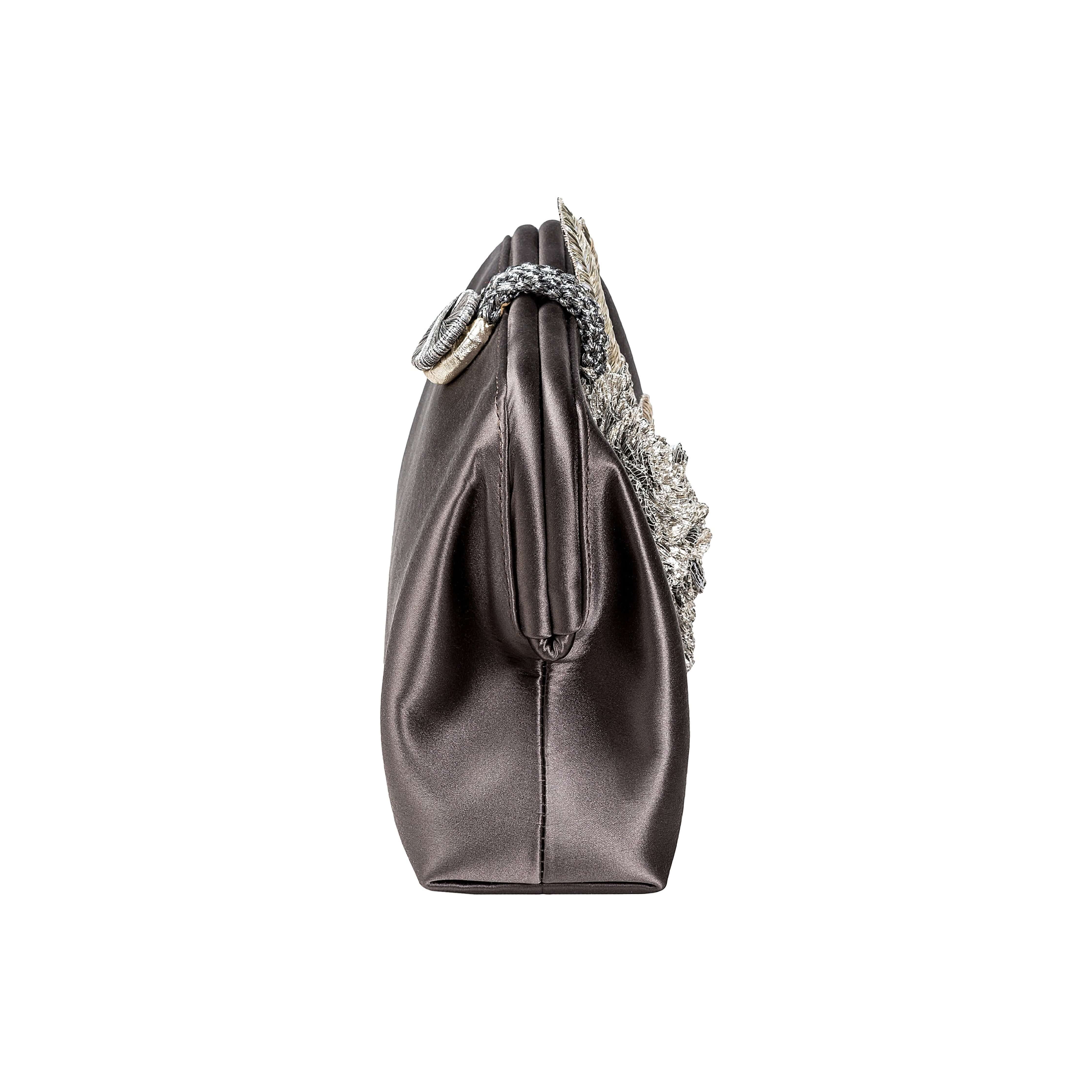 Side view of the Fiora Electrum Pouch Bag, showcasing its elegant silver flower embellishment on a satin finish.
