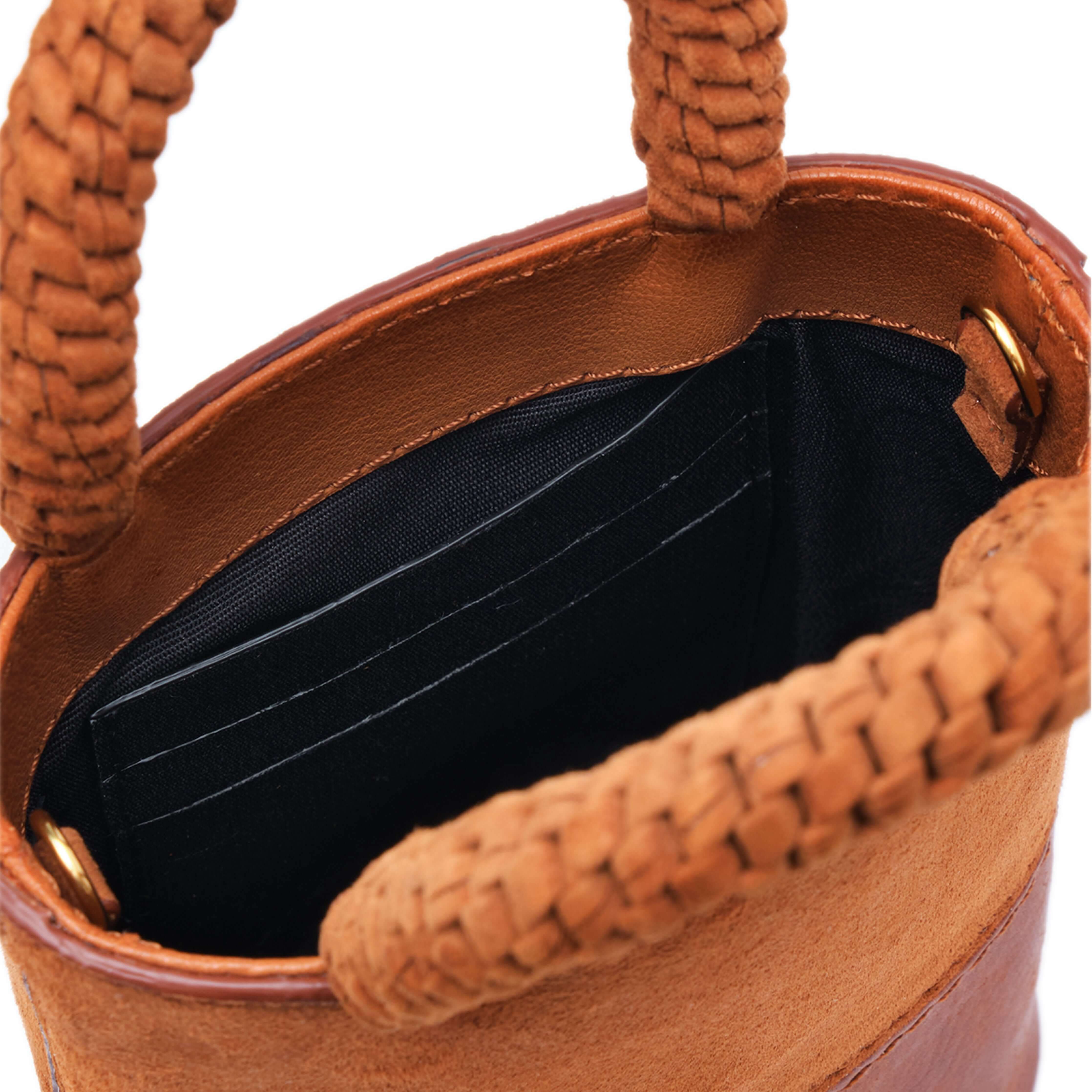 Interior view of Rovena Camello Mini Bucket Bag showcasing spacious pockets and braided handles in natural leather.